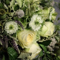 a bouquet of white roses and green leaves