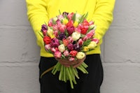 a man holding a bunch of tulips